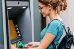 woman putting her card into an ATM