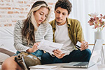 woman using calculator while viewing bills