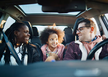 parents sitting in car with daughter