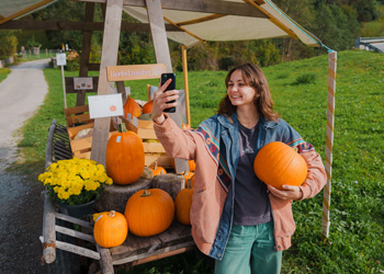 woman taking selfie with pumpkins