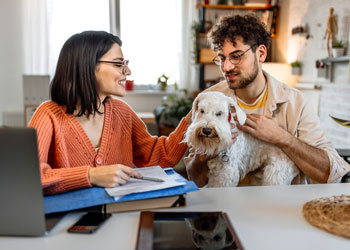 couple in front of laptop with dog