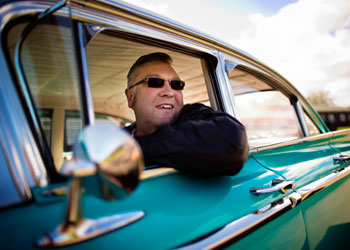 man driving classic car