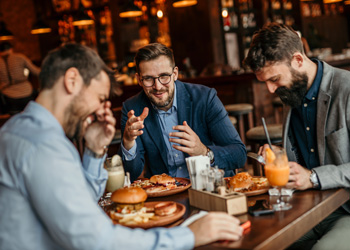 men eating and laughing at restaurant