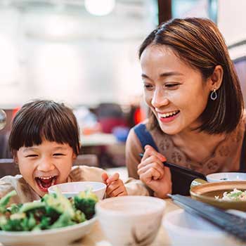 mom and daughter eating at restaraunt