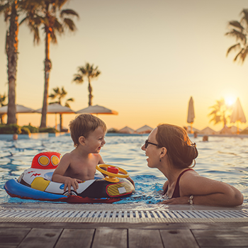 mom and young son in pool on vacation 