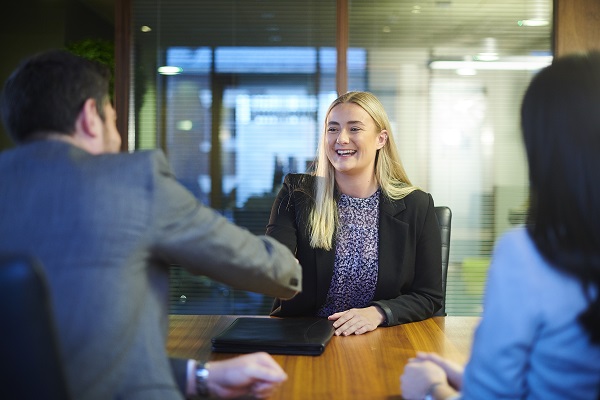 young female interviewee shaking hands with hiring manager