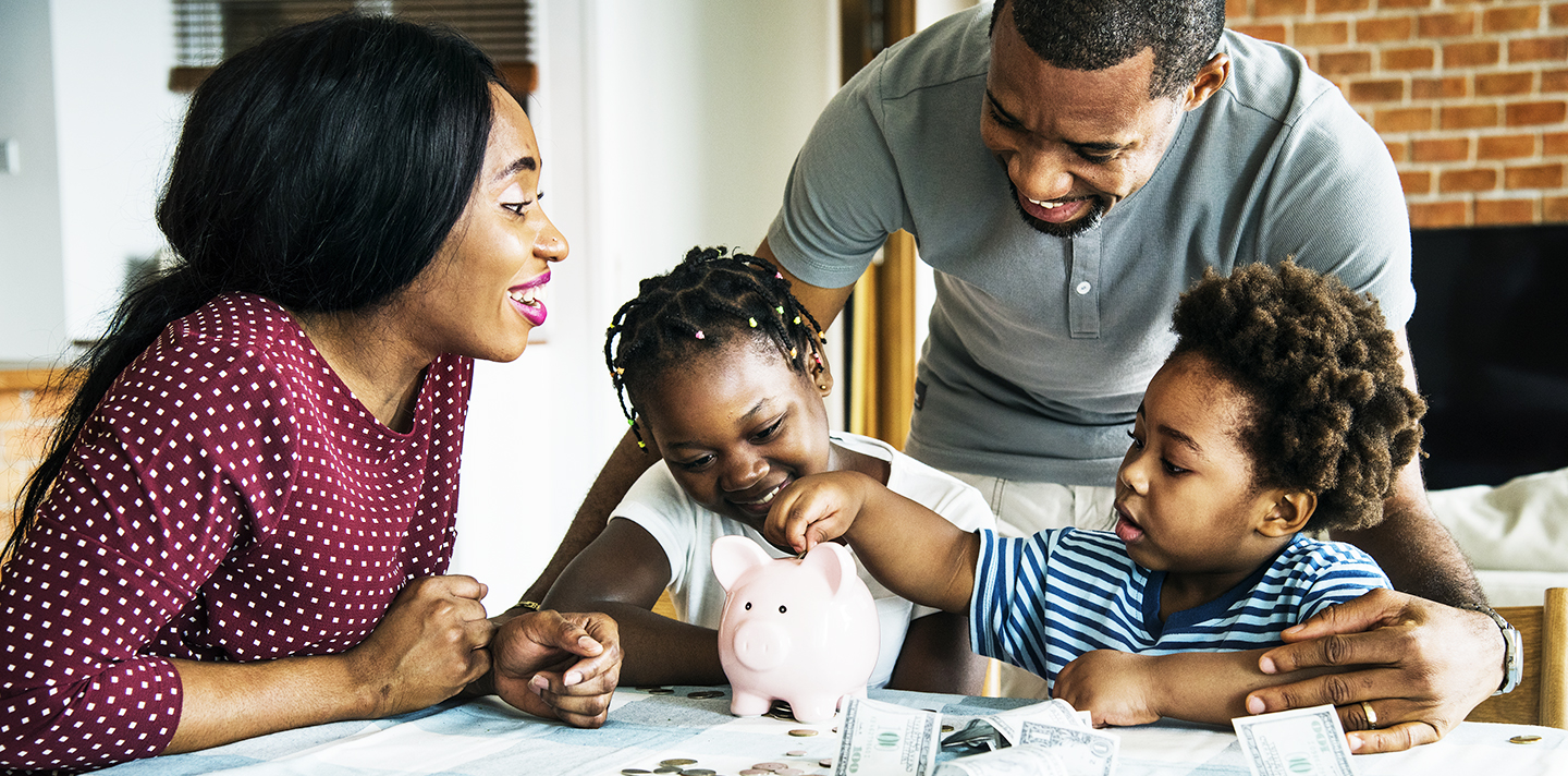 parents and children putting money in piggy bank