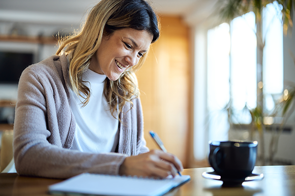 woman smiling and writing